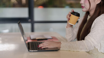 Asian adult remote worker professional productivity cafe laptop computer business project drink coffee