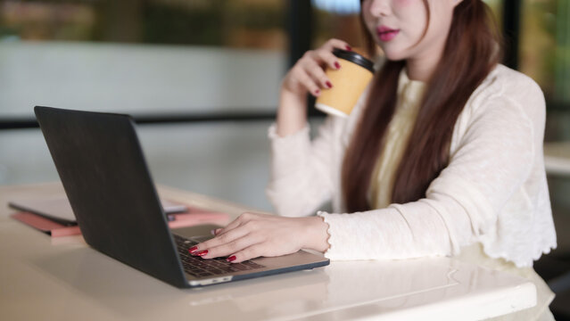 Asian adult woman remote working laptop cafe freelance professional business online entrepreneur digital nomad lifestyle flexible productivity focus