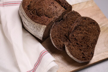 Fresh baked wholegrain no east bread on wood and marble board.