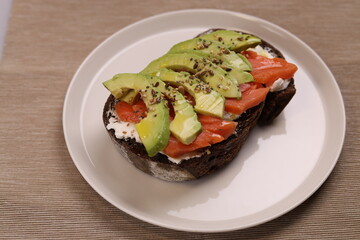 Delicious breakfast toast of wholegrain bread with smoked salmon cream cheese and avocado.