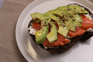 Breakfast toast of wholegrain bread with smoked salmon cream cheese and avocado.