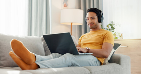 Relax, headphones and laptop with man on sofa for streaming service, film website and comfortable. Movie subscription, watching series and entertainment with person in living room of home for search