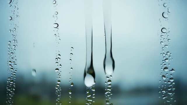 Regentropfen auf Fensterscheibe &ndash; Nahaufnahme mit flie&szlig;endem Wasser