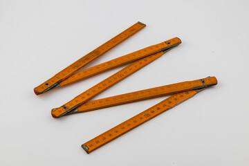Wooden folding ruler laid out on a white background for measurement tasks