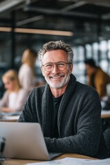 Fototapeta premium Smiling senior professional with laptop in modern office, symbolizing leadership, experience, career growth, corporate success, creativity, technology, and teamwork.