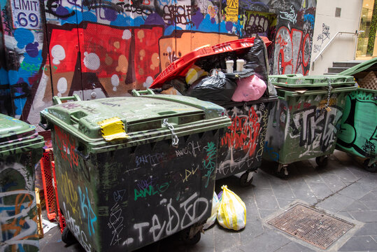 Skip bins in an alley with street art and graffiti