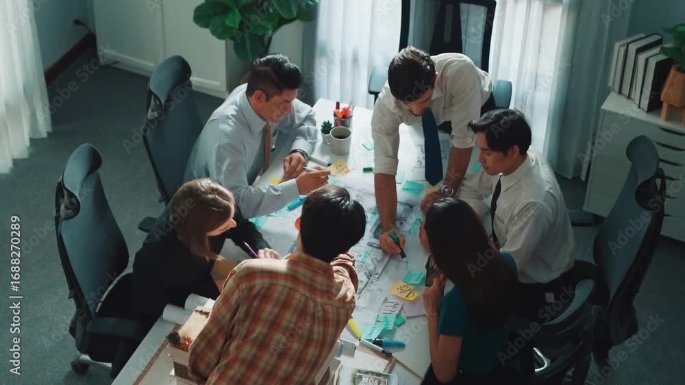Poster group of diverse team planning strategy while sitting at table with project plan. top aerial view of