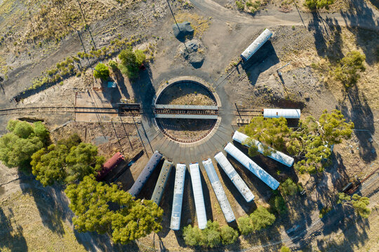 Aerial view of an old railway turntable with abandoned train carriages.