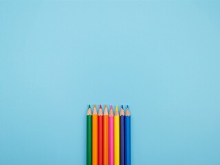 Colored Pencils Array on Light Blue Sharp Points and Wooden Textures Displayed Top View