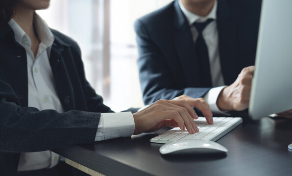 Two business colleagues having a discussion, working on computer during meeting at office. Businessmen planning and solution, working together, business collaboration