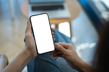 Mockup blank white screen mobile phone. Woman hand holding, using smartphone at coffee shop, template for mobile app design, social media marketing, close up