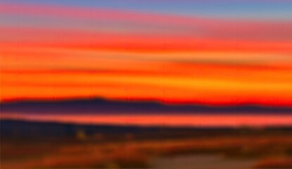 Naklejka premium Blurry sunset over mountains and water