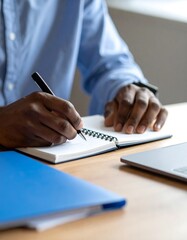 Person writing in notebook at desk
