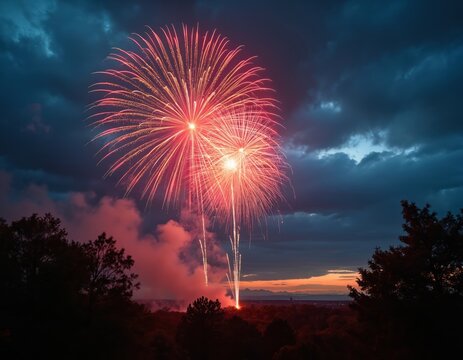 Spectacular fireworks explode in night sky over silhouetted trees, landscape. Brilliant red, orange, white bursts illuminate dark clouds, creating festive, celebratory atmosphere for holiday event. - Powered by Adobe