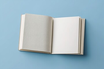 Minimalist top-down book mockup with two floating books: one with a textured linen cover, the other open to a blank page layout, set against a light blue background