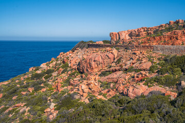 Spectacular red cliffs rise along the west coast of Corsica between Calvi and Galeria France with stunning Mediterranean sea views