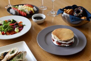 Different kind of food served in a fancy restaurant including fruits, salad and grilled chicken