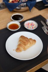 Croissant on a white plate in a cafe or restaurant
