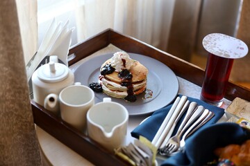 Pancake served with maple syrup and whipped cream on top and other garnishing 