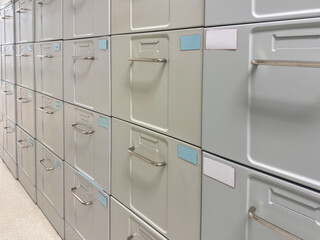 Metal filing cabinets with handles and labels for office archive and document storage, medical...