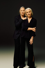 Mature women enjoying love and fashion in a stylish embrace under soft lighting