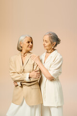 Elegant and timeless love shines between two mature women in fashionable attire