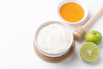 Yogurt, lime and honey on white background