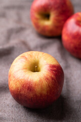 Red apple fruit (Envy apple) on brown fabric background