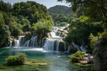 Obraz premium Lush waterfalls cascade down rocky terrain, framed by dense forest