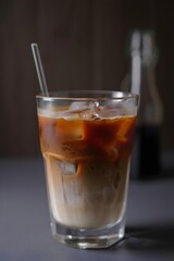 Refreshing Iced Latte: Close-up Studio Shot, Dark Moody Background, Glass with Straw.