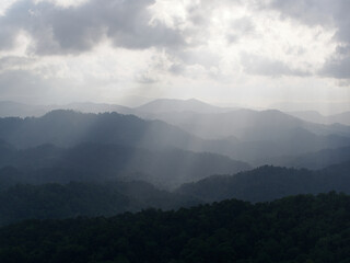 Obraz premium Sunset in the mountains with clouds and sunbeams, Thailand