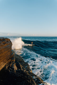 Adult male surfing waves at China Wall in Honolulu, Hawaii