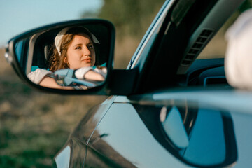 Woman reflected in car side mirror outdoors