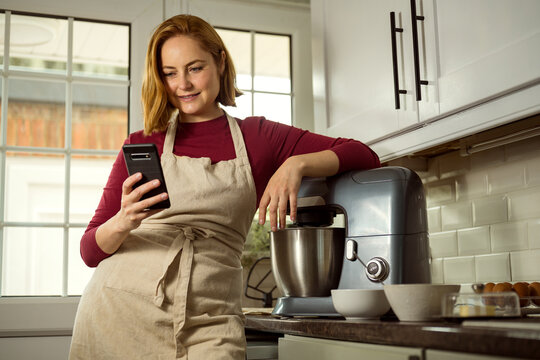 Millennial woman searching recipe online, cooking at home