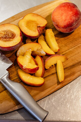 Freshly sliced peaches on a wooden cutting board