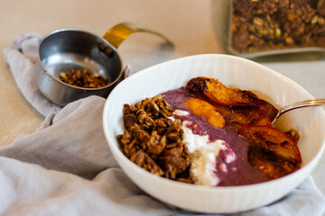 Breakfast bowl with braised peaches, yogurt, granola, and chia