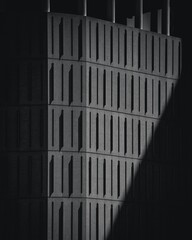 A modern stone building facade with clean geometric lines, minimalist design, and textured stone surfaces, highlighting contemporary architecture in natural light.