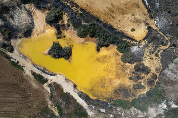 Aerial view of industrial pollution contaminating the environment and destroying vegetation. Yellow...
