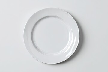 A clean, empty, round white dinner plate sits on a plain white background, subtly shadowed