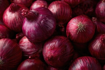 A close-up shot of a pile of deep red onions, glistening with moisture, their papery skins showing subtle striations