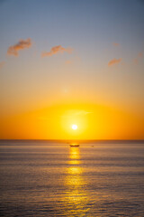 Fototapeta premium Sunset sky over sea in the evening, Dusk sky horizon. Fiery orange sunset paints sky. Golden hour magic, breathtaking horizon, peaceful evening