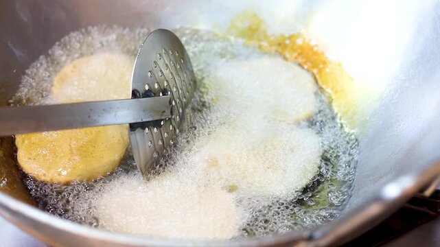 Indian bread or puri or pudi being fried in hot oil