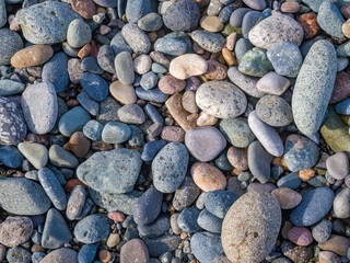 Colorful smooth pebbles arranged on a serene beach