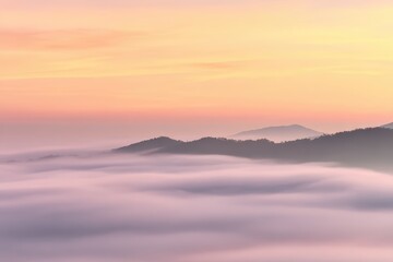 Obraz premium Serene mountains pierce soft, pink-tinged clouds under a pastel sunrise, creating a tranquil vista of natural beauty and atmospheric perspective