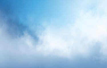 Fototapeta premium Sky abstraction. A dreamy, soft focus image of wispy white clouds fading into a graduated blue background, suggesting altitude and atmosphere