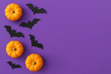Halloween Flat Lay with Pumpkins and Bats on a purple background. 
