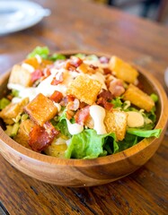 Fresh Caesar salad in wooden bowl