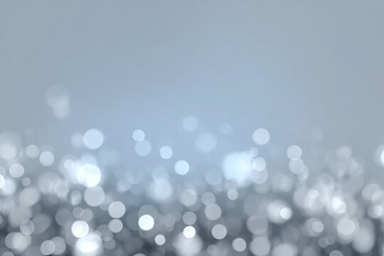 Abstract background features sparkling bokeh lights in grayscale, with a soft gradient fade to light blue at the top, evoking a dreamy or festive mood