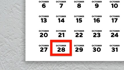 Close-up of the date October 28th marked with a red cursor on the wall calendar 2025