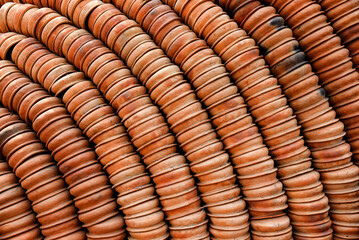 Rows of neatly arranged terracotta pots forming an intriguing pattern outdoors, showcasing craftsmanship and utility in traditional pottery. Perfect for cultural, artisan crafts, or heritage themes.